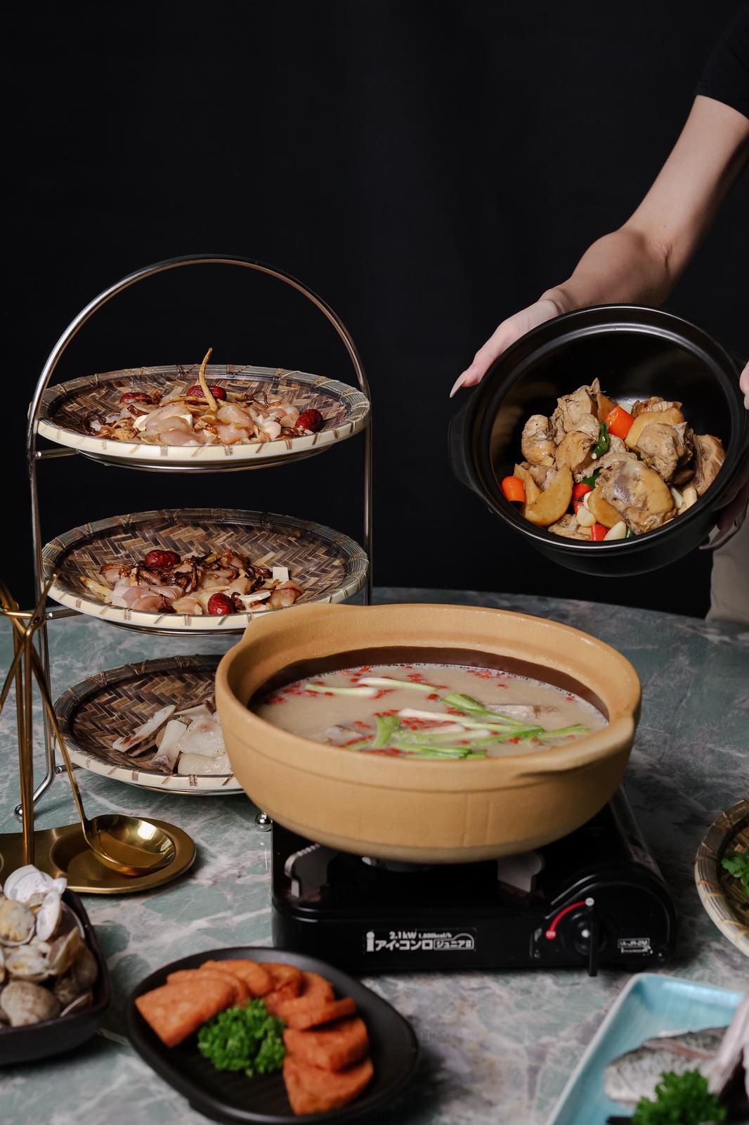 Diverse array of dishes including a hot pot and other food items on a table.