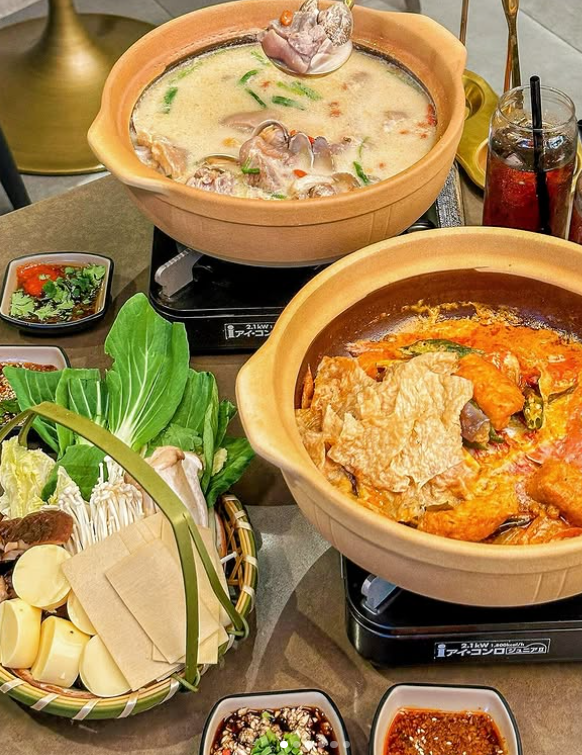 Two hot pots with various ingredients on a table in Clarke Quay Restaurant.