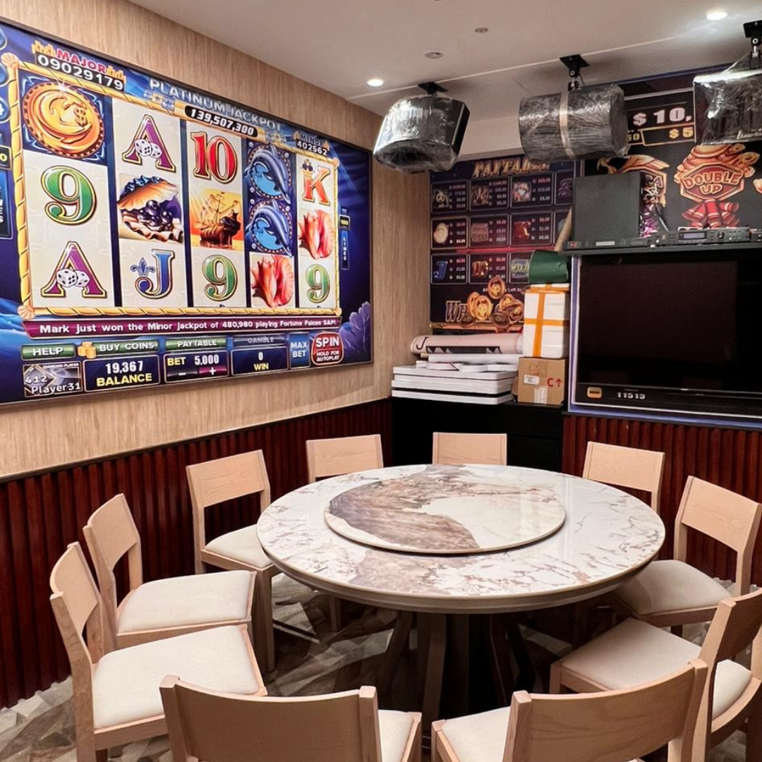 Casino-themed room with slot machine display, table, and chairs in Clarke Quay.