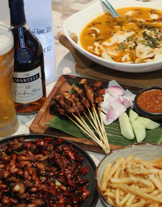 Assorted dishes including a bottle of Martell cognac, skewers, and bowls of food on a table.