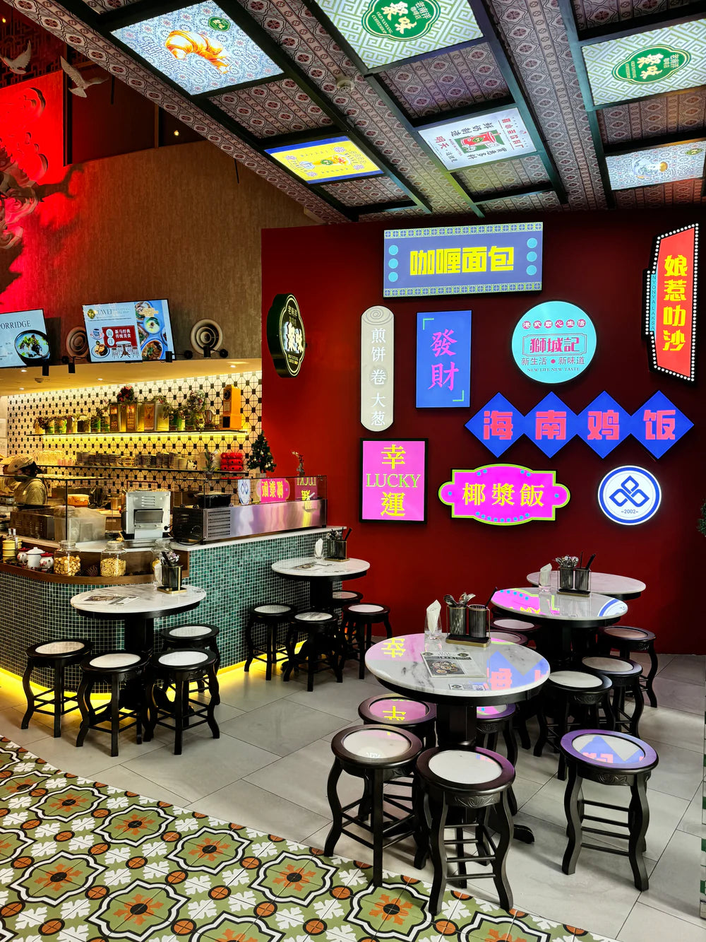 Nanyang Restaurant interior with tables, chairs, and colorful signs on a red wall.