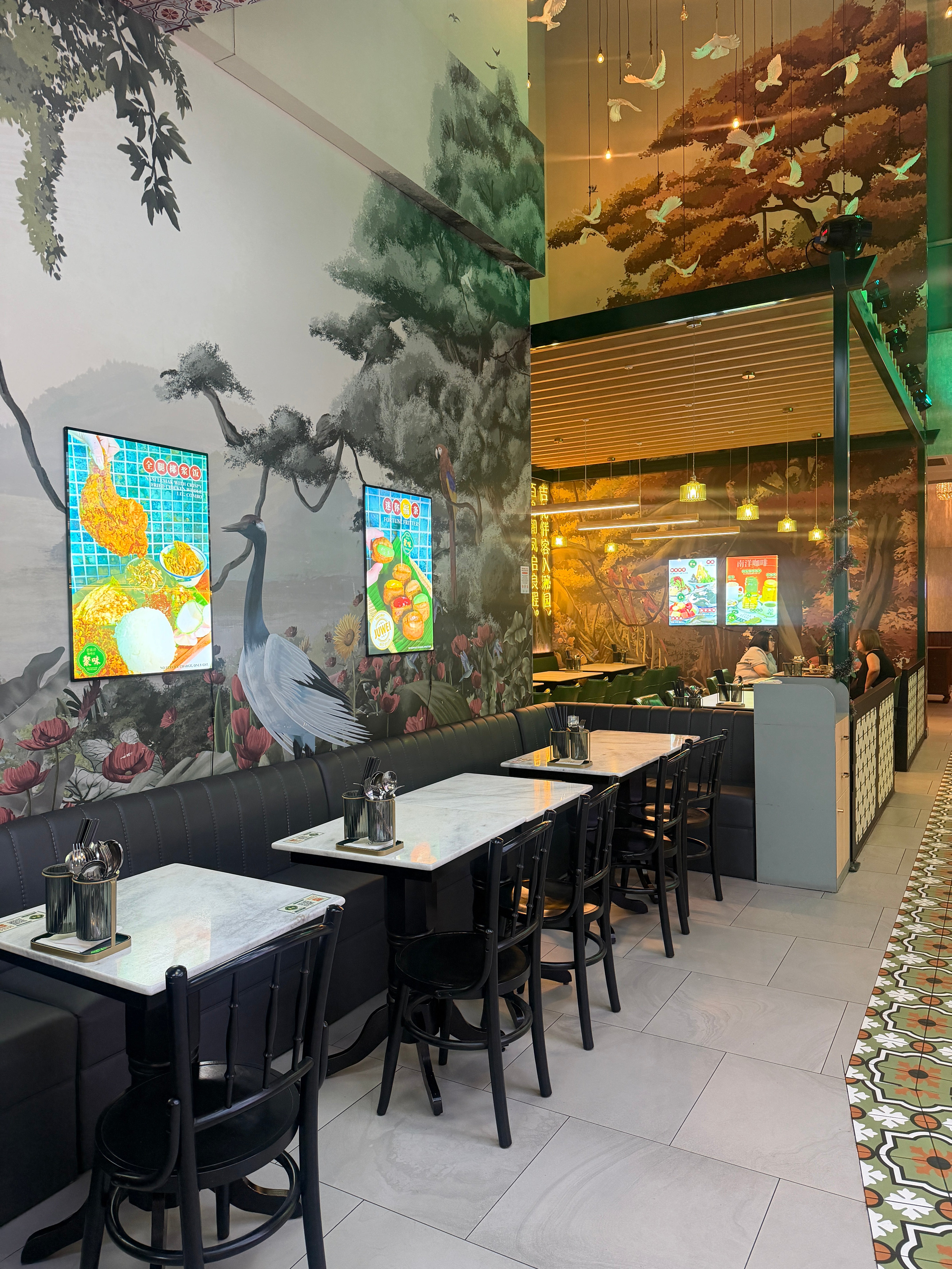 Nanyang Restaurant interior with tables, chairs, and a decorative wall.