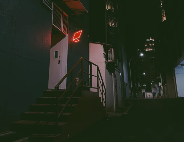 Staircase leading up to a building with a red light at night.